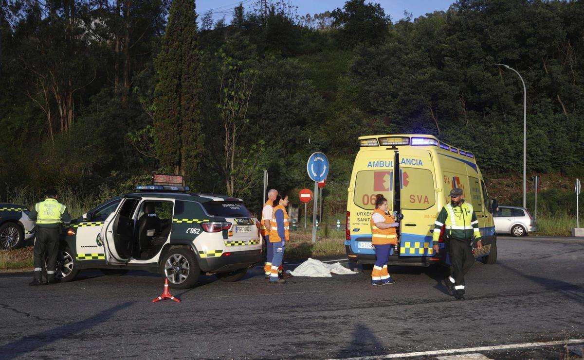 El cuerpo del fallecido, tapado con una sábana, junto a una ambulancia.