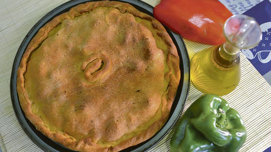 Yoli de la Fuente muestra la empanada lista para comer. Abajo, recién sacada del horno.