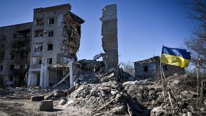 Una bandera ucraniana ondea frente a un edificio destruido en un bombardeo ruso en Orikhiv, en la región de Zaporiyia, en Ucrania