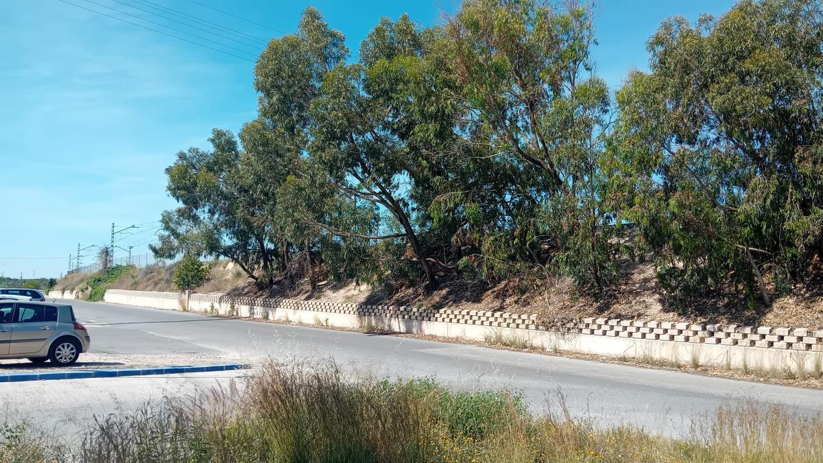 Carretera que va al barrio Granada, con la línea ferroviaria al fondo