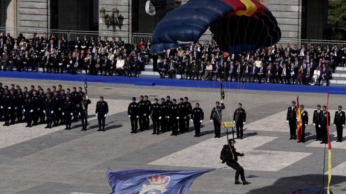 Un paracaidista de los GEO aterriza con una bandera en la plaza del Palacio Real.