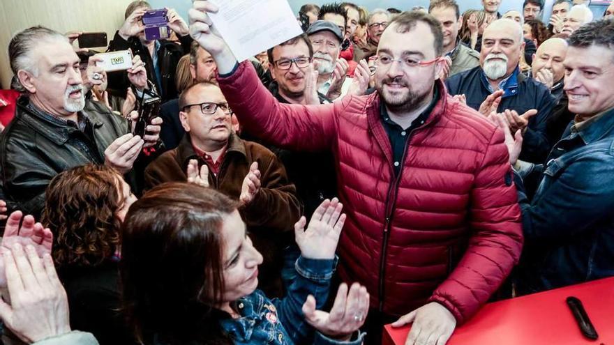 Adrián Barbón enseña el documento que oficializa la presentación de su candidatura entre el aplauso de los militantes congregados en la sede de la FSA, con Adriana Lastra en primer término.