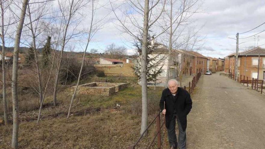 Un vecino de Villaferrueña pasea por el puente de la localidad. Al fondo, a la izquierda, la fragua en reconstrucción.