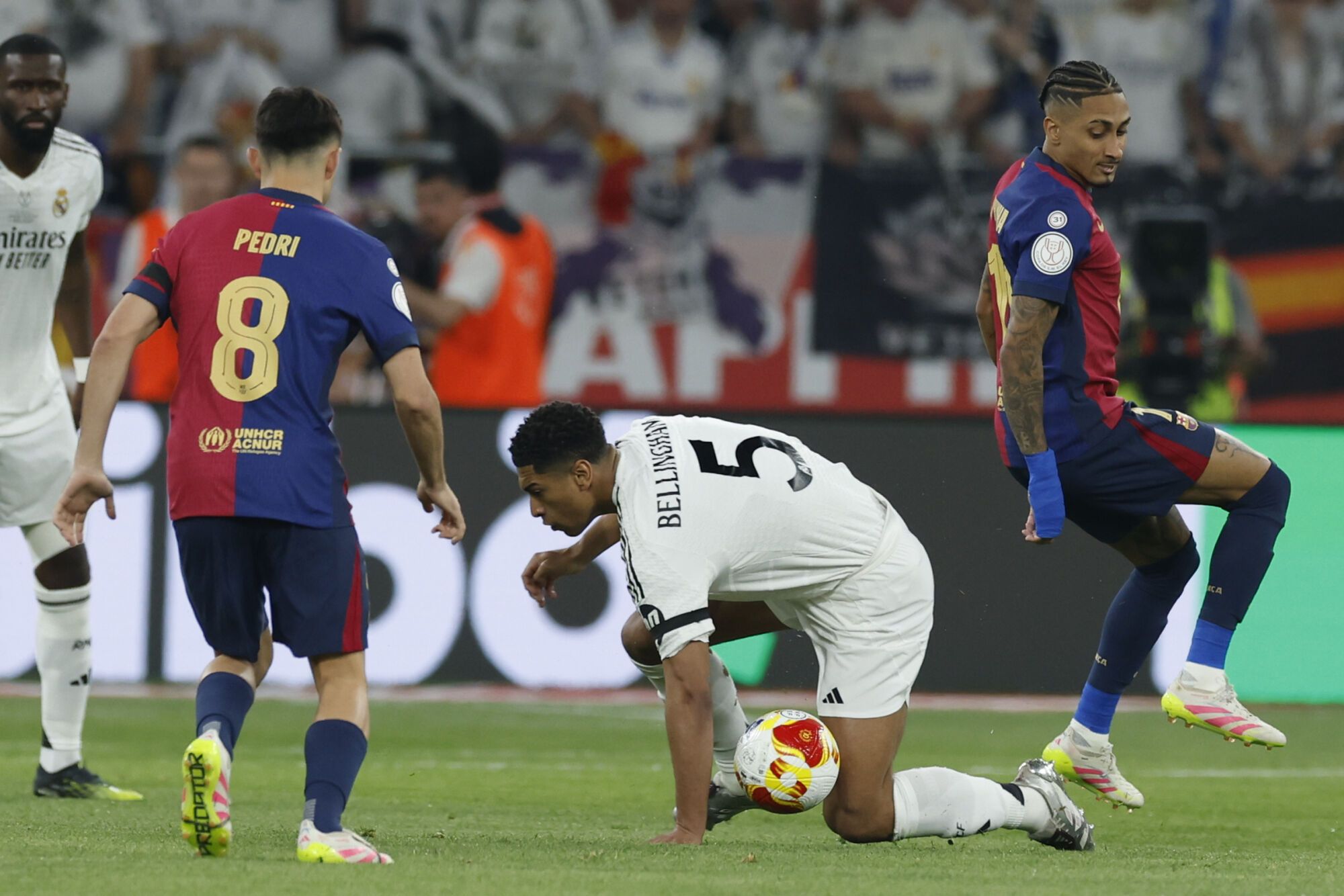 SEVILLA, 26/04/2025.- La centrocampista británico del Real Madrid Jude Bellingham (d) cae al suelo junto a Pedri, del FC Barcelona, durante la final de la Copa del Rey que disputan Real Madrid y FC Barcelona hoy sábado en el estadio de La Cartuja, en Sevilla. EFE/Julio Muñoz