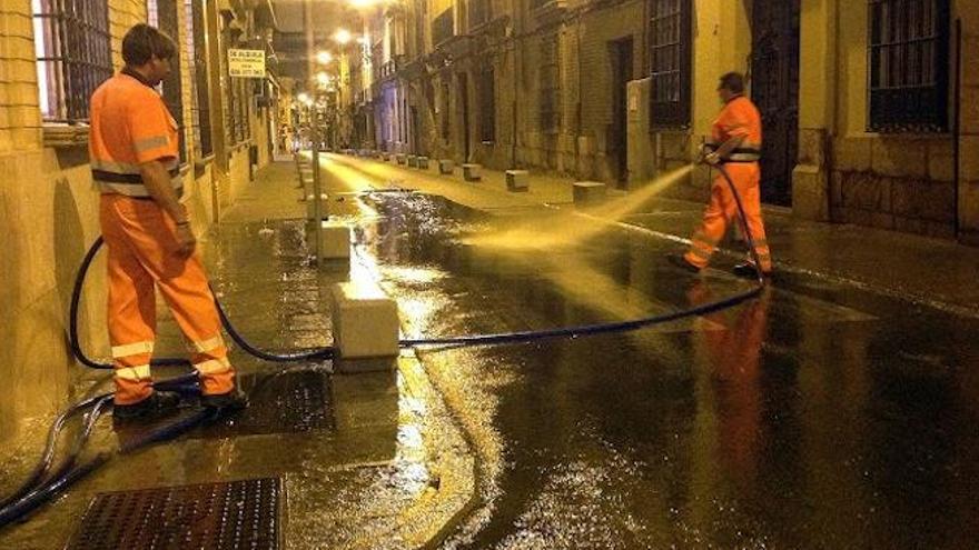 Operarios municipales desarrollando el baldeo de calles durante la noche.