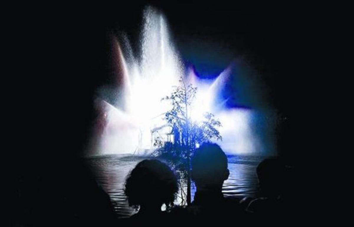 Una parella intenta disfrutar de l’espectacle ’Splash!’ malgrat que un arbust els tapa la visió.