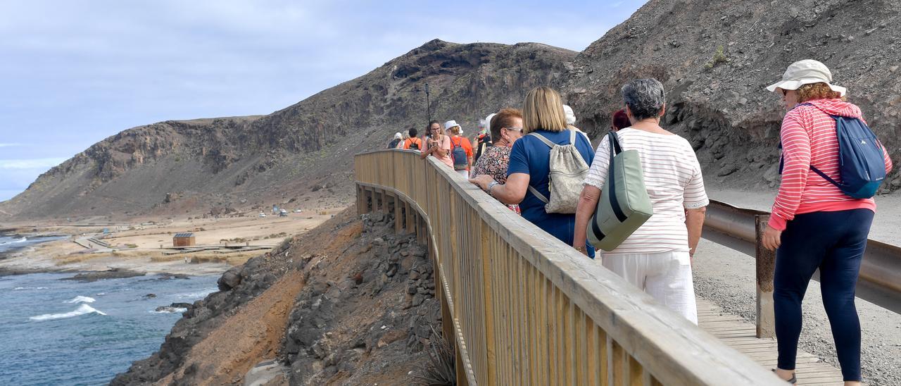 Varias personas transitan por el acceso peatonal hacia El Confital