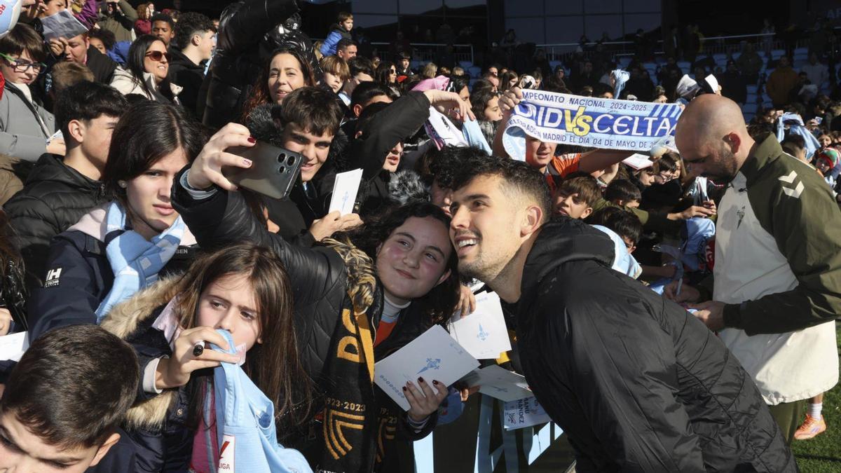 Carlos Domínguez sonríe para un selfie junto a una joven aficionada del Celta, con Claudio tras ellos.