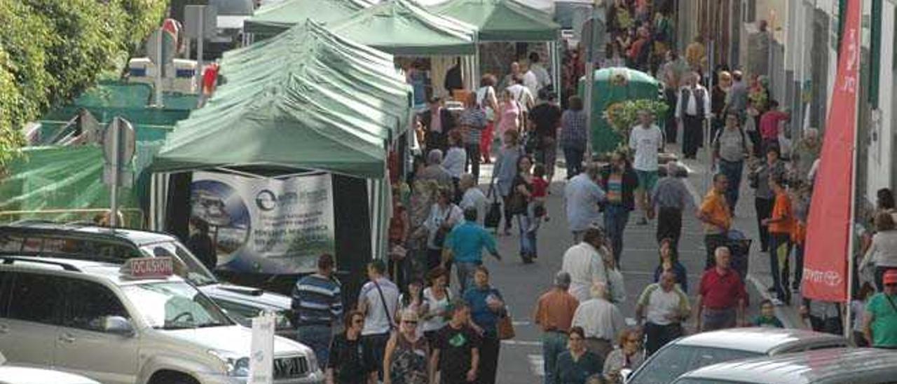 Imagen de personas paseando por una feria comercial en las calles de Arucas.