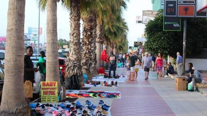 Un grupo de manteros vende sus productos en el paseo de Aguamarina.