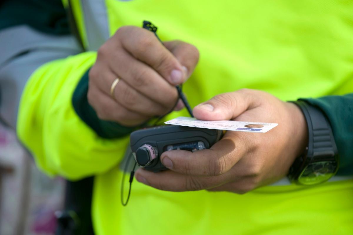 Un agente de Tráfico de la Guardia Civil pone una sanción a un conductor.