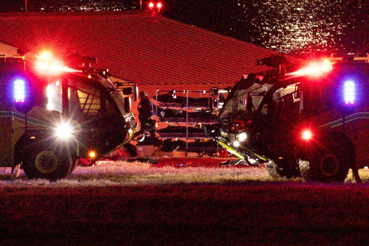 Los cuerpos son transportados junto a vehículos de emergencia, cerca del lugar del accidente después de que el vuelo 5342 de American Eagle chocara con un helicóptero Black Hawk mientras se aproximaba al Aeropuerto Nacional Reagan de Washington y se estrellara en el río Potomac.