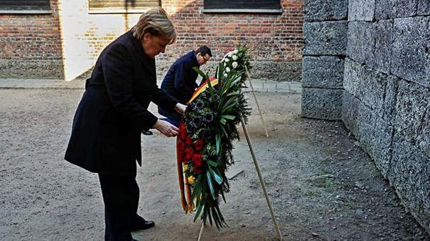 Merkel col·loca una corona de flors al «mur de la mort» del camp d&#039;Auschwitz.