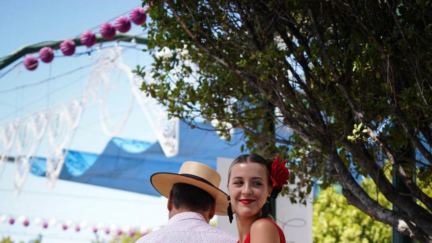 Una joven vestida de flamenca a lomos de un caballo en el Cortijo de Torres.