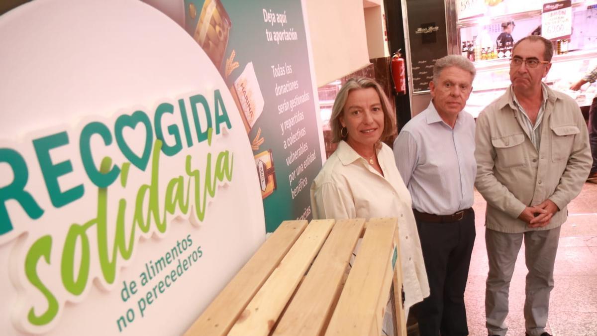 Isabel Albás, Rafael Revuelto y Antonio Álvarez, en el punto de recogida de alimentos del mercado de La Corredera.