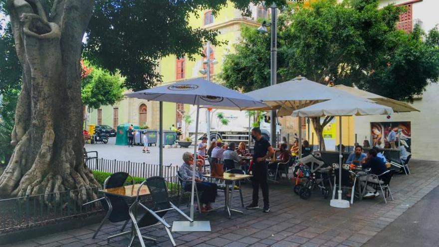 Un trabajador de una terraza de Santa Cruz de Tenerife atiende a uno de sus clientes. | | MARÍA PISACA