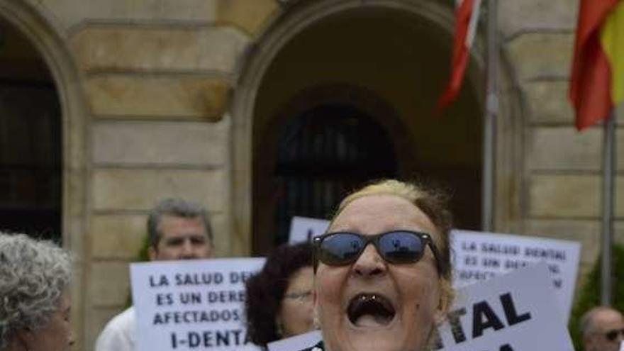 Una de las afectadas, María Paz Sanz, enseña su boca en la manifestación del pasado jueves en la plaza del Ayuntamiento.