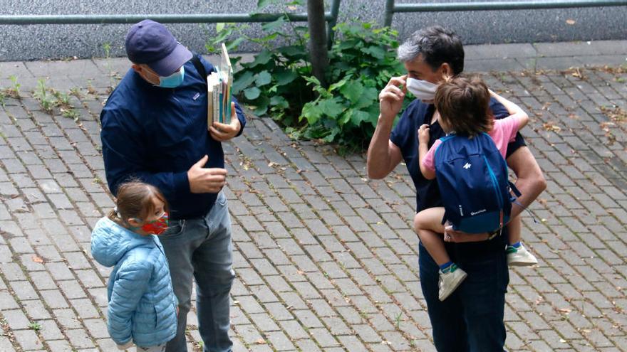 Dos pares conversen a les portes de l&#039;Institut Escola Costa i Llobera abans de deixar-hi els fills