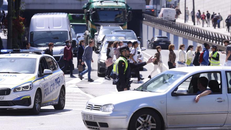 Un agente dirige el tráfico en Oviedo. | LUISMA MURIAS / JUAN PLAZA / MIKI LÓPEZ