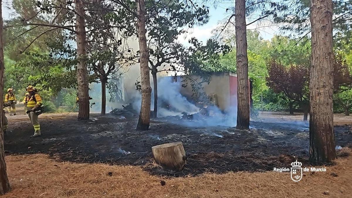 Varios bomberos trabajan sobre el terreno quemado para evitar que las llamas se reaviven.