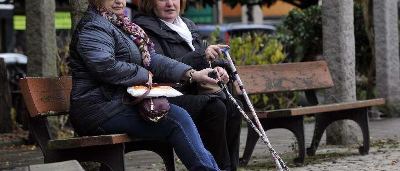 María del Mar Pérez y Luisa Fernández, en un banco de Mieres.