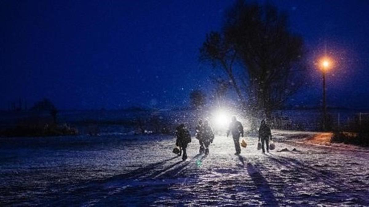 Un grupo de refugiados caminan de noche entre la nieve cerca de la localidad serbia de Miratovac.