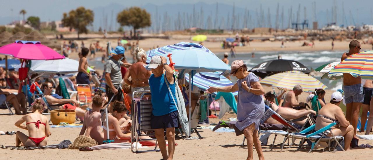 Nombrosos banyistes es refugiaven de la calor a la platja del Port de Sagunt.