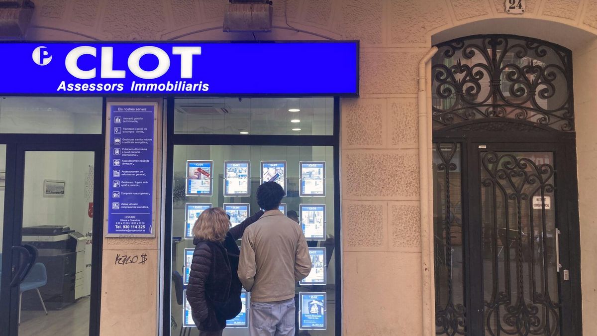 Dos personas observan los anuncios de pisos de alquiler en una inmobiliaria del barrio del Clot de Barcelona.