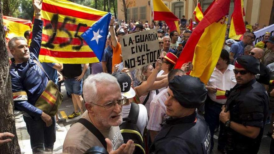 Los mossos, entre manifestantes a favor y en contra de la Guardia Civil ante el cuartel de Barcelona. // Efe