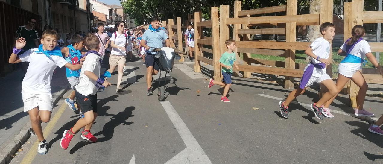 Niños corren delante de un carrretón durante el encierro ecológico