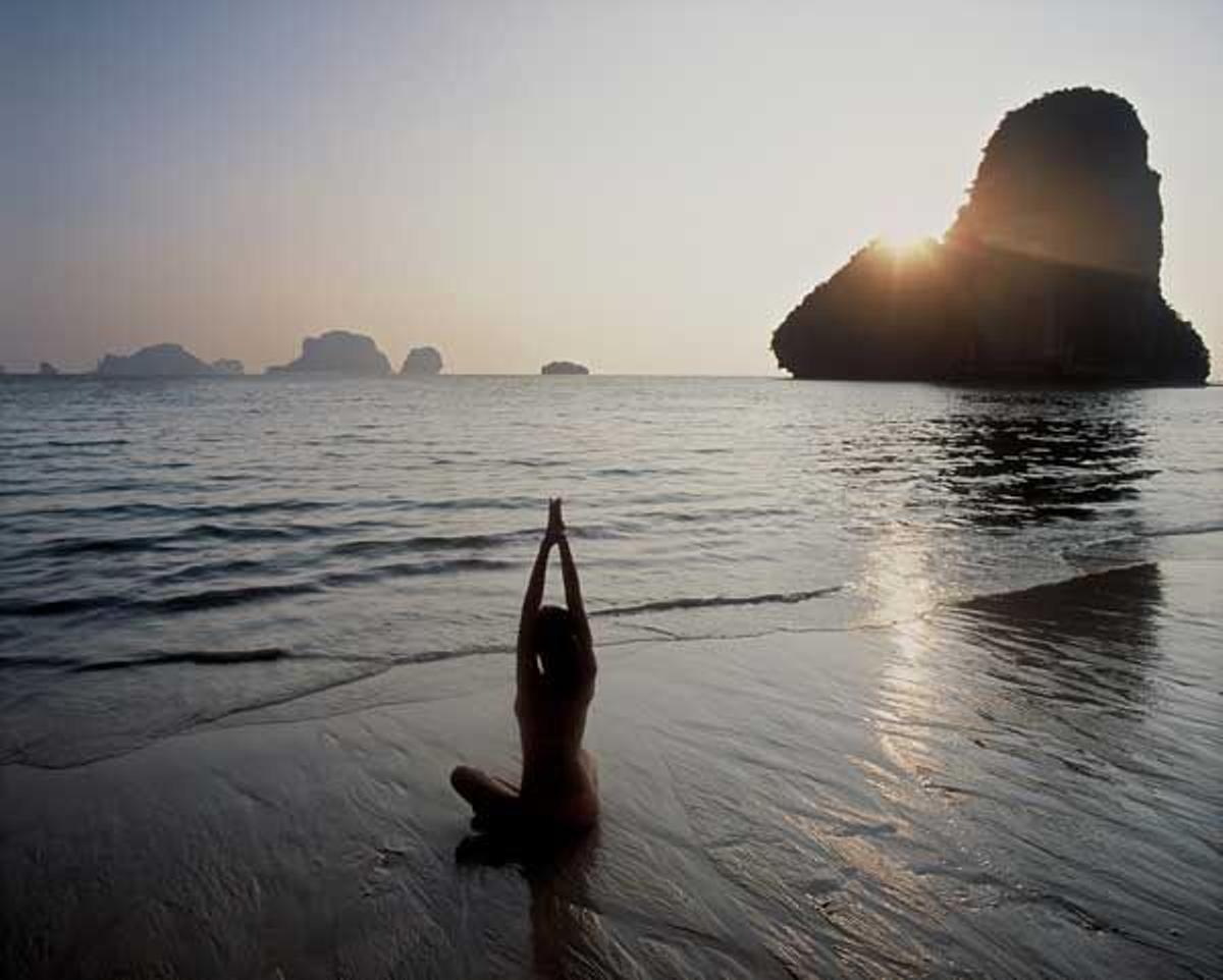 Mujer practicando yoga en la playa de Phra Nang en Krabi, Tailandia.