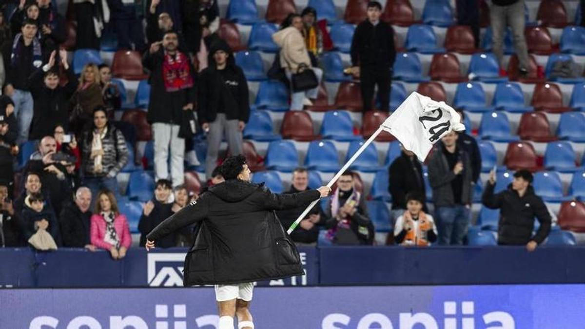 Cömert cogió un banderín del Levante, al que colocó encima su camiseta del Valencia, para celebrar el triunfo en el derbi con los valencianistas