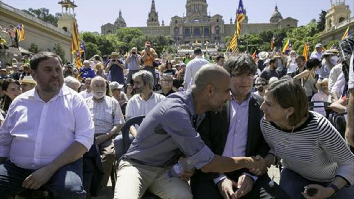 Guardiola saluda a Forcadell en presencia de Puigdemont y Junqueras, ayer, en la falda de Montjuïc.