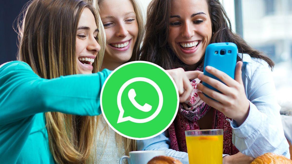 Varias mujeres consultan un teléfono móvil.