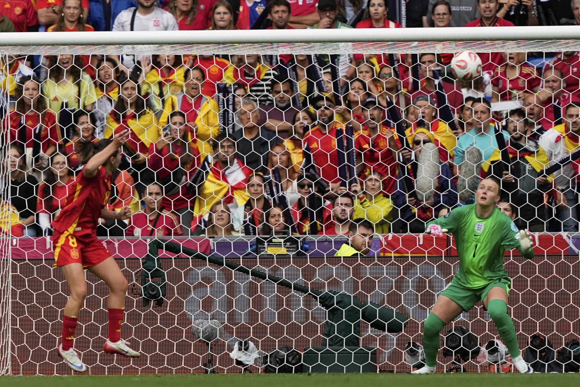 Spain's Mariona Caldentey, left, scores her sides first goal past England goalkeeper Hannah Hampton during the Women's Euro 2025 final soccer match between England and Spain at St. Jakob-Park in Basel, Switzerland, Sunday, July 27, 2025. (AP Photo/Martin Meissner)