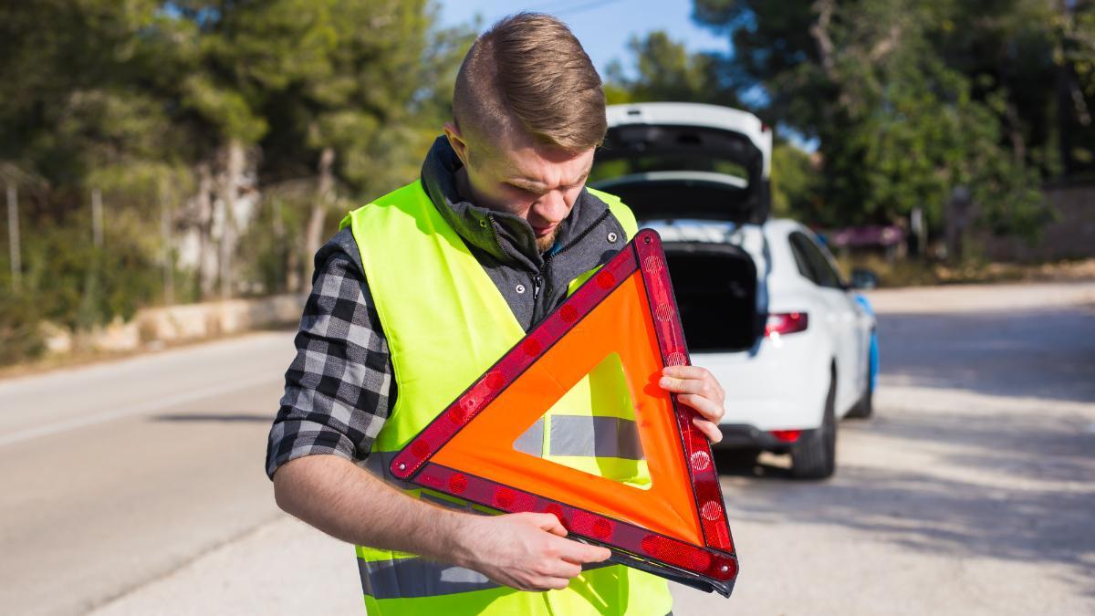 Un hombre con el triangulo de emergencia