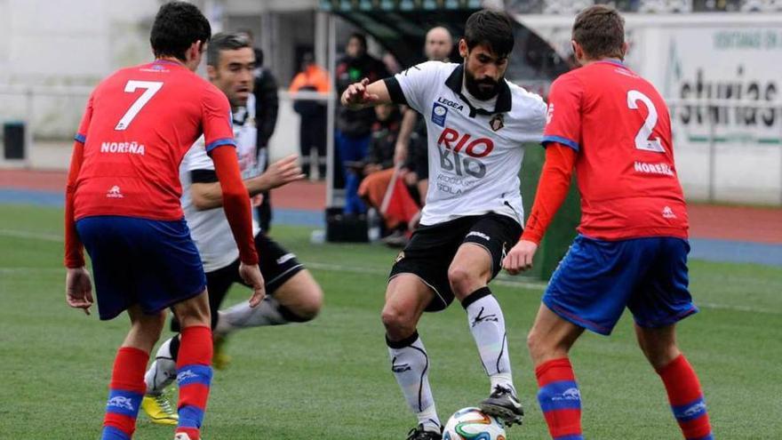 Noel Alonso controla el balón ante la oposición de dos jugadores del Condal, y con Invernón a la expectativa.