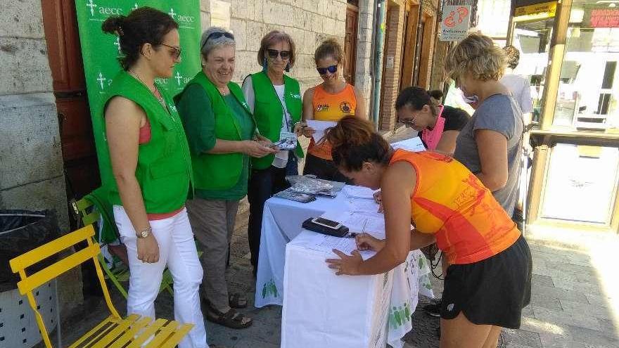 Un grupo de toresanas firma en los folletos repartidos por las voluntarias de la AECC de Toro.