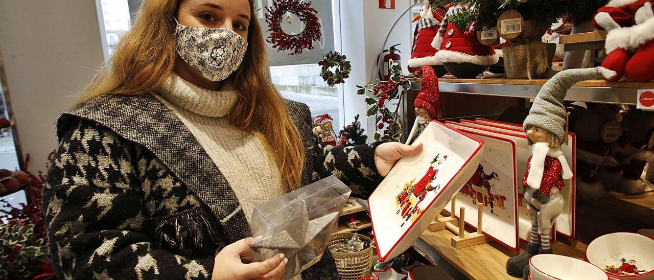 Jimena Martínez escoge entre varios artículos de decoración navideña en una tienda gijonesa.