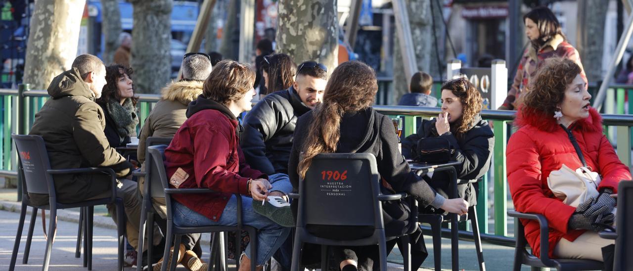 Gente pasenado y en terrazas al sol en el Arenal y el paseo de Bouzas