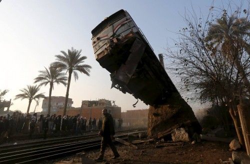 A crowd looks at the wreckage of a train crash in Beni Suef, south of Cairo
