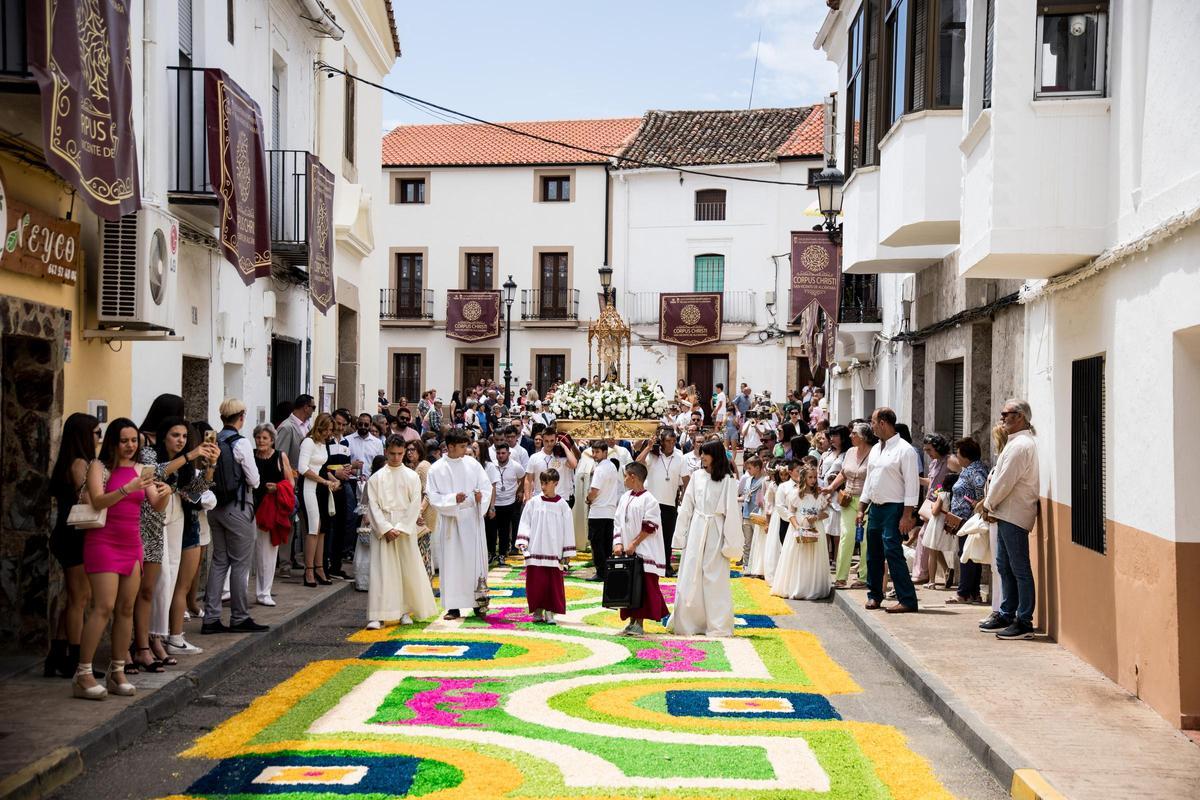 El Santísimo atraviesa las calles de San Vicente de Alcántara sobre una alfombra de colores realizada con corcho.
