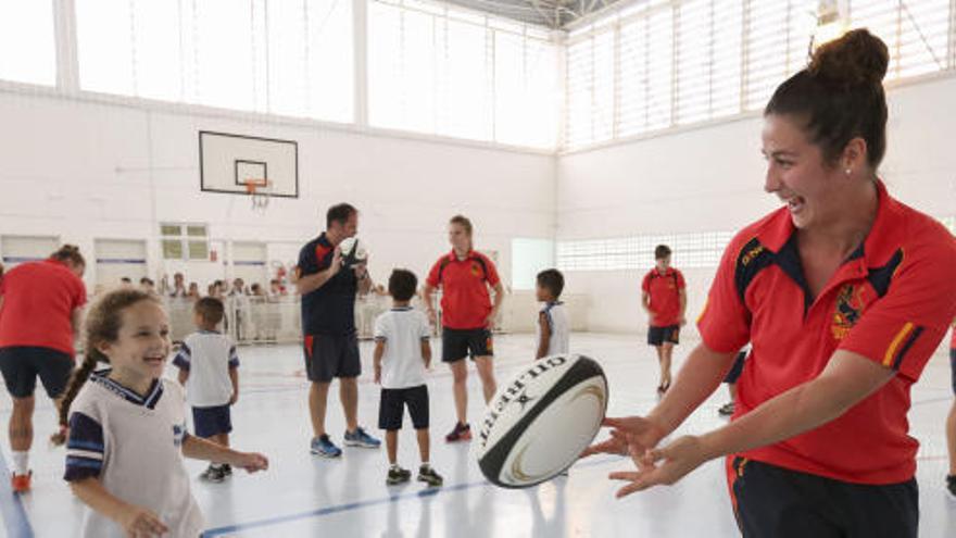 Jugadoras de la selección española enseñando rugby en un colegio.