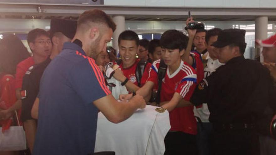 Musfafi firmando autógrafos a su llegada a China.