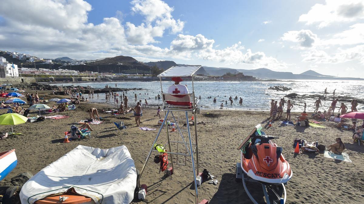 Un socorrista de la Cruz Roja, de espaldas, vigila la playa de El Puertillo, en Arucas.