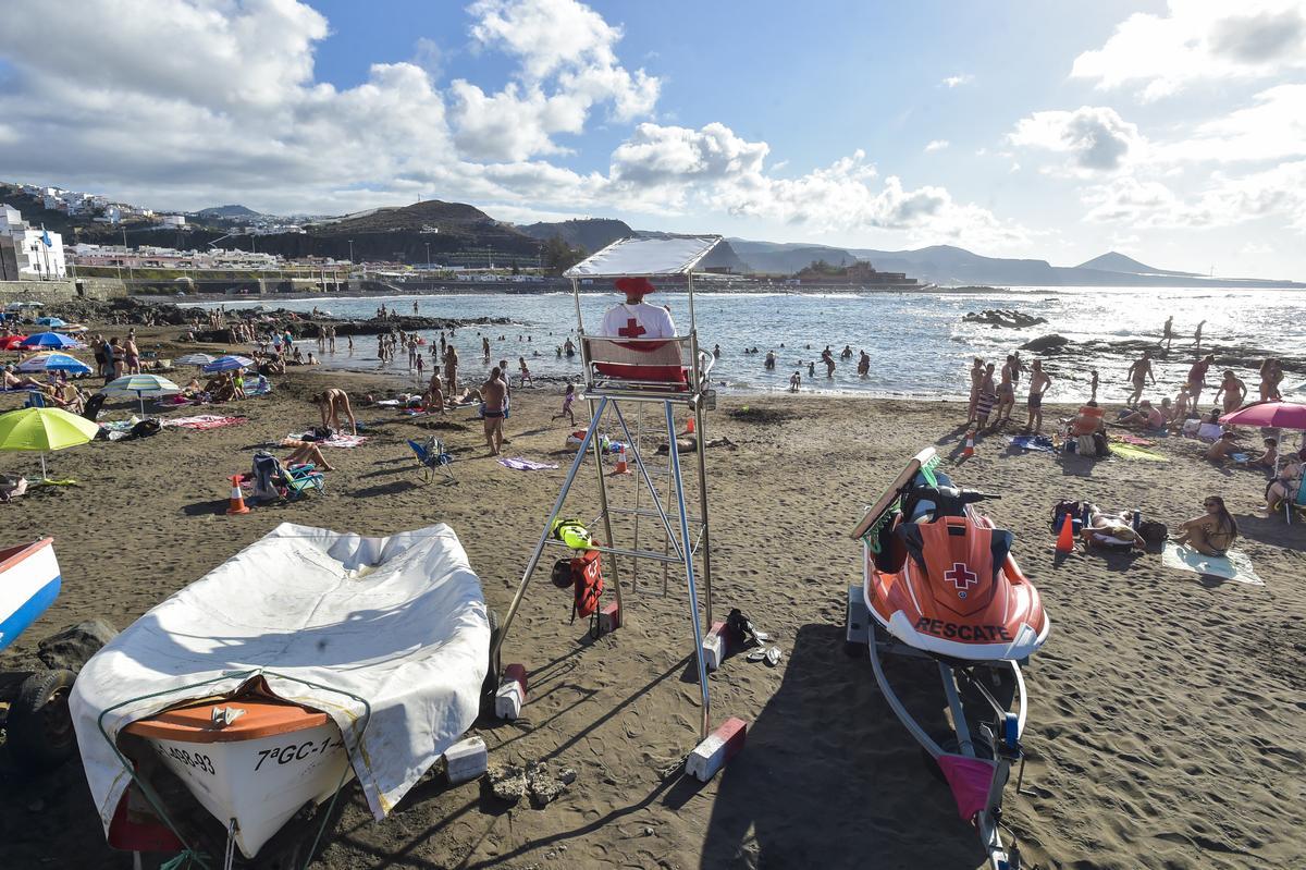 Un socorrista de la Cruz Roja, de espaldas, vigila la playa de El Puertillo, en Arucas.