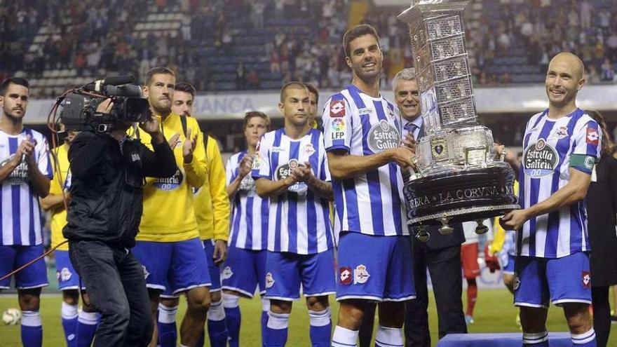 Juan Domínguez y Laure, con sus compañeros por detrás, con el trofeo Teresa Herrera en la pasada edición de 2014.