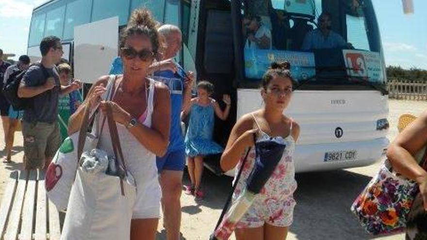 Un grupo de turistas baja del autobús en ses Illetes el pasado verano.