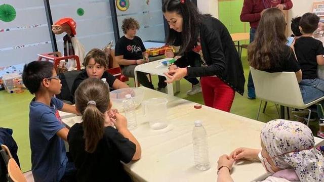 Los niños realizando una actividad junto a la monitora. // FdV