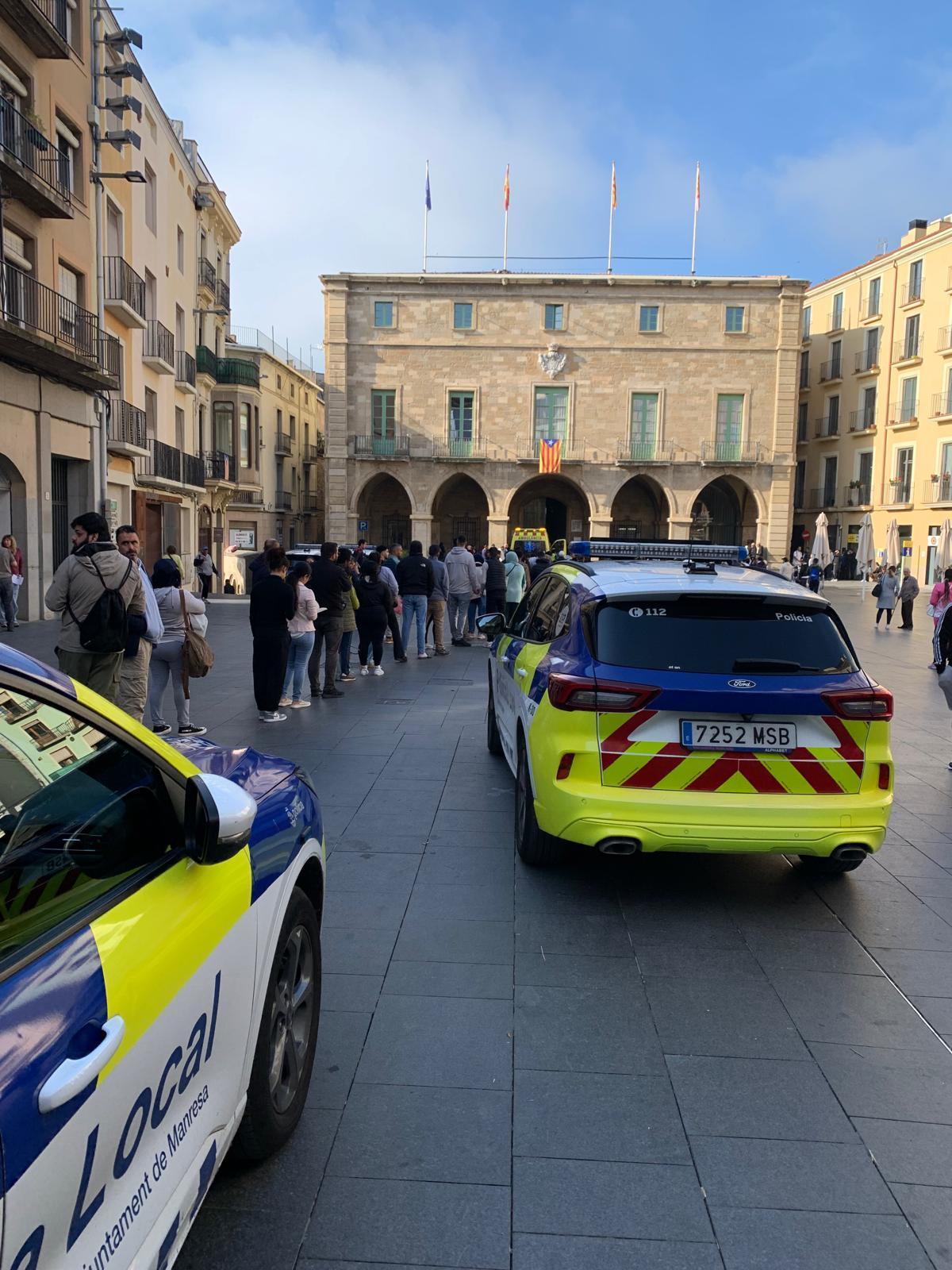 La cua del segon dia a la plaça Major, amb vehicles de policia